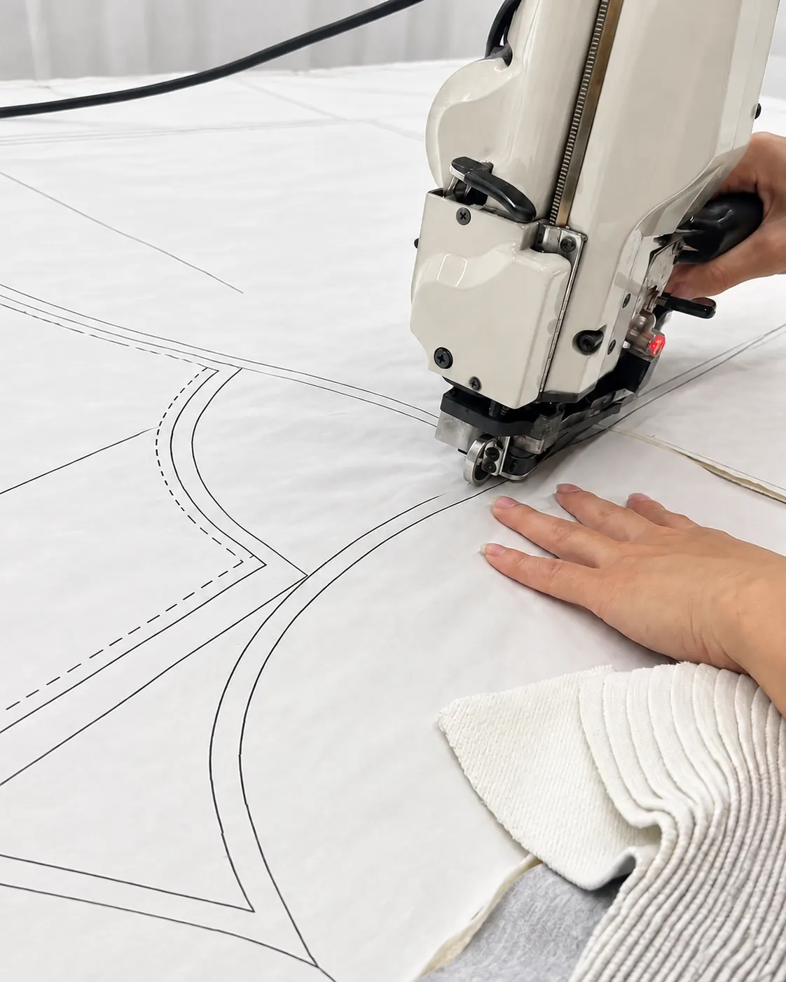 Cutting machine following pattern outlines on cream fabric