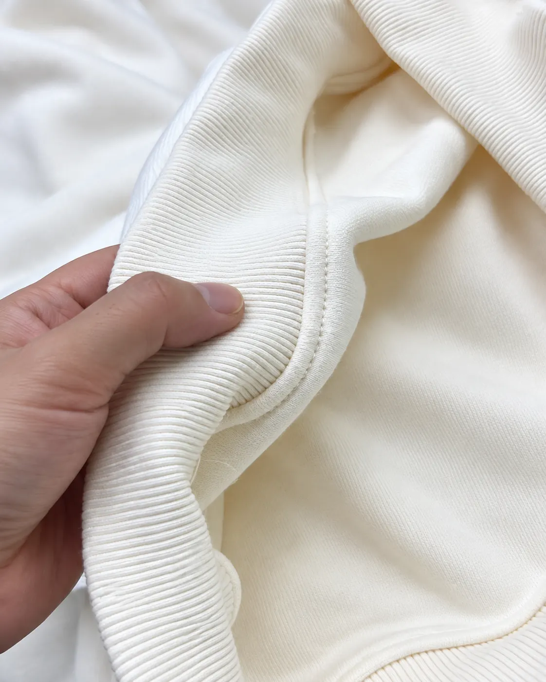 Hands opening a rib seam to show the inside seam finish