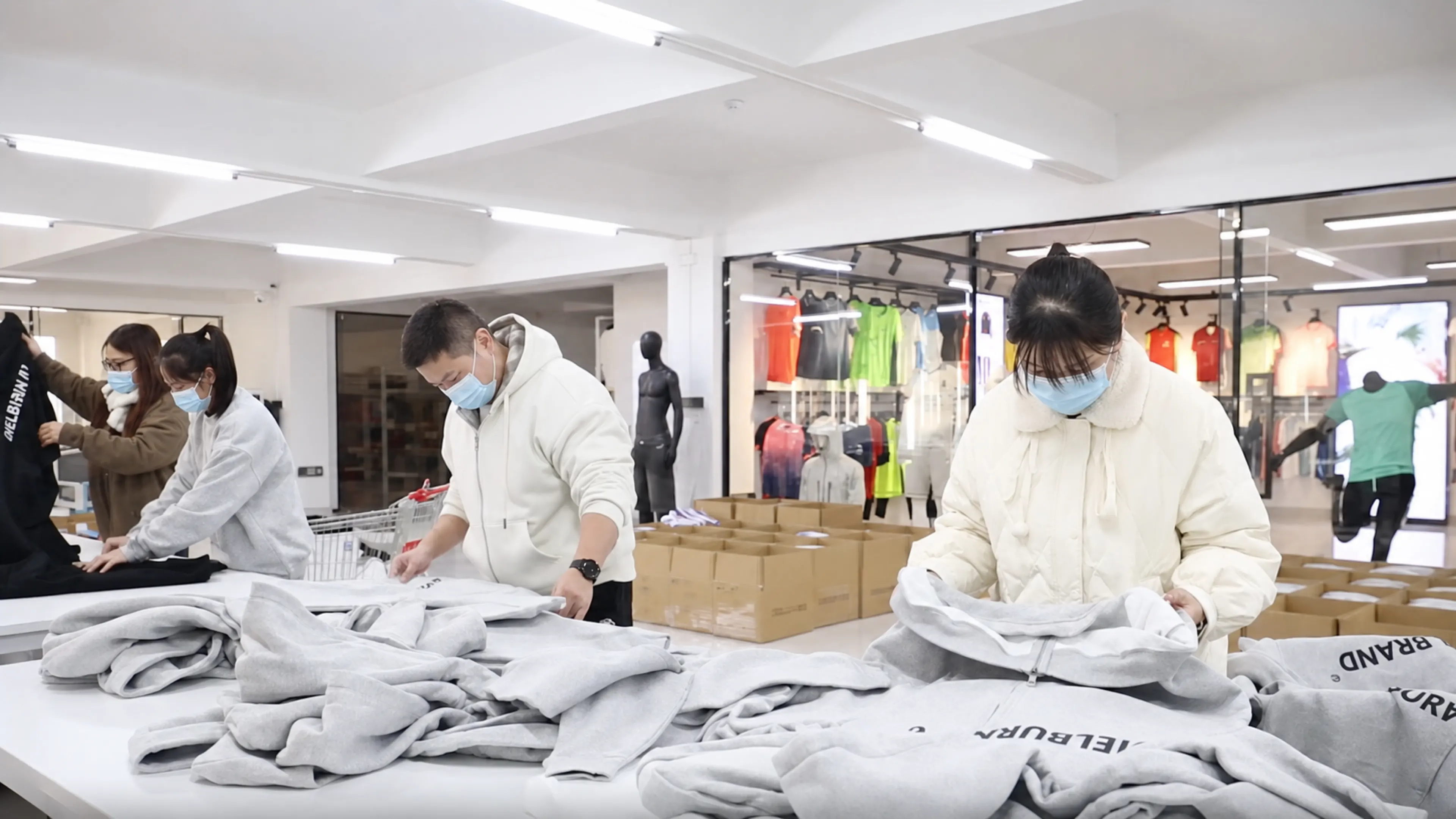 DRIOV quality team reviewing finished black and white garments before packing release