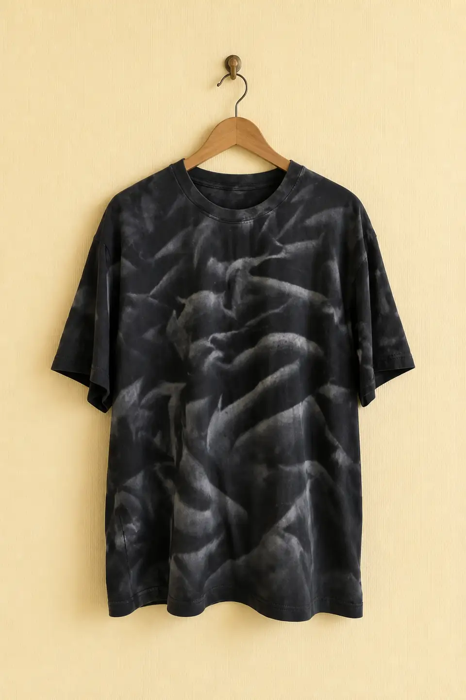 Black tie-dye shirt displayed on a wooden hanger