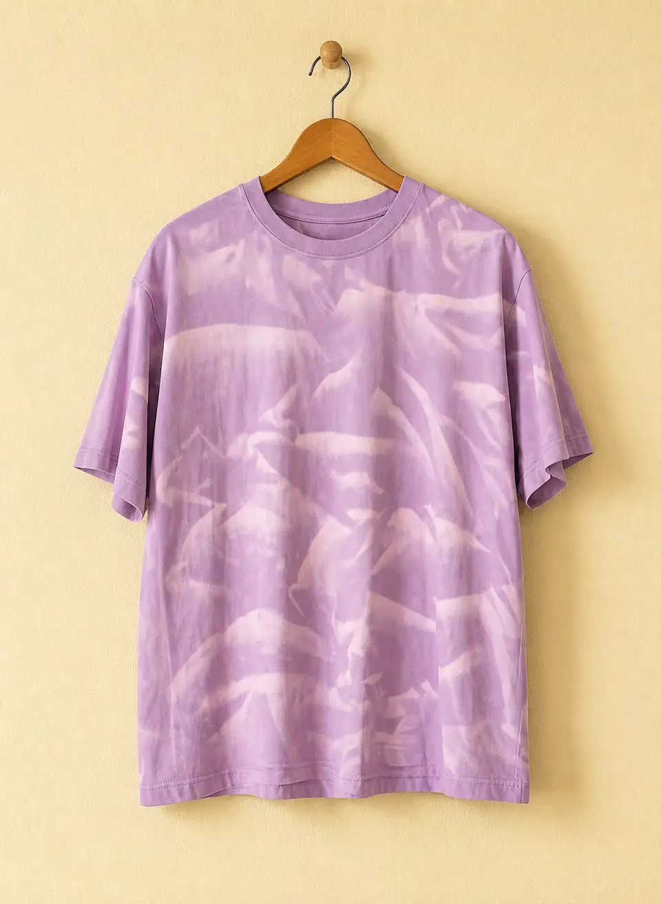 Lavender tie-dye shirt displayed on a wooden hanger